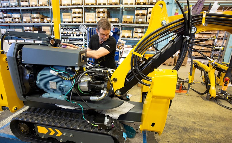 Robotens armsystem är tredelat till skillnad från den tvådelade på grävmaskinen. Med tre delar kan arbeten även utföras uppåt i tak. Här monterar Niklas Abrahamsson på armsystemet.