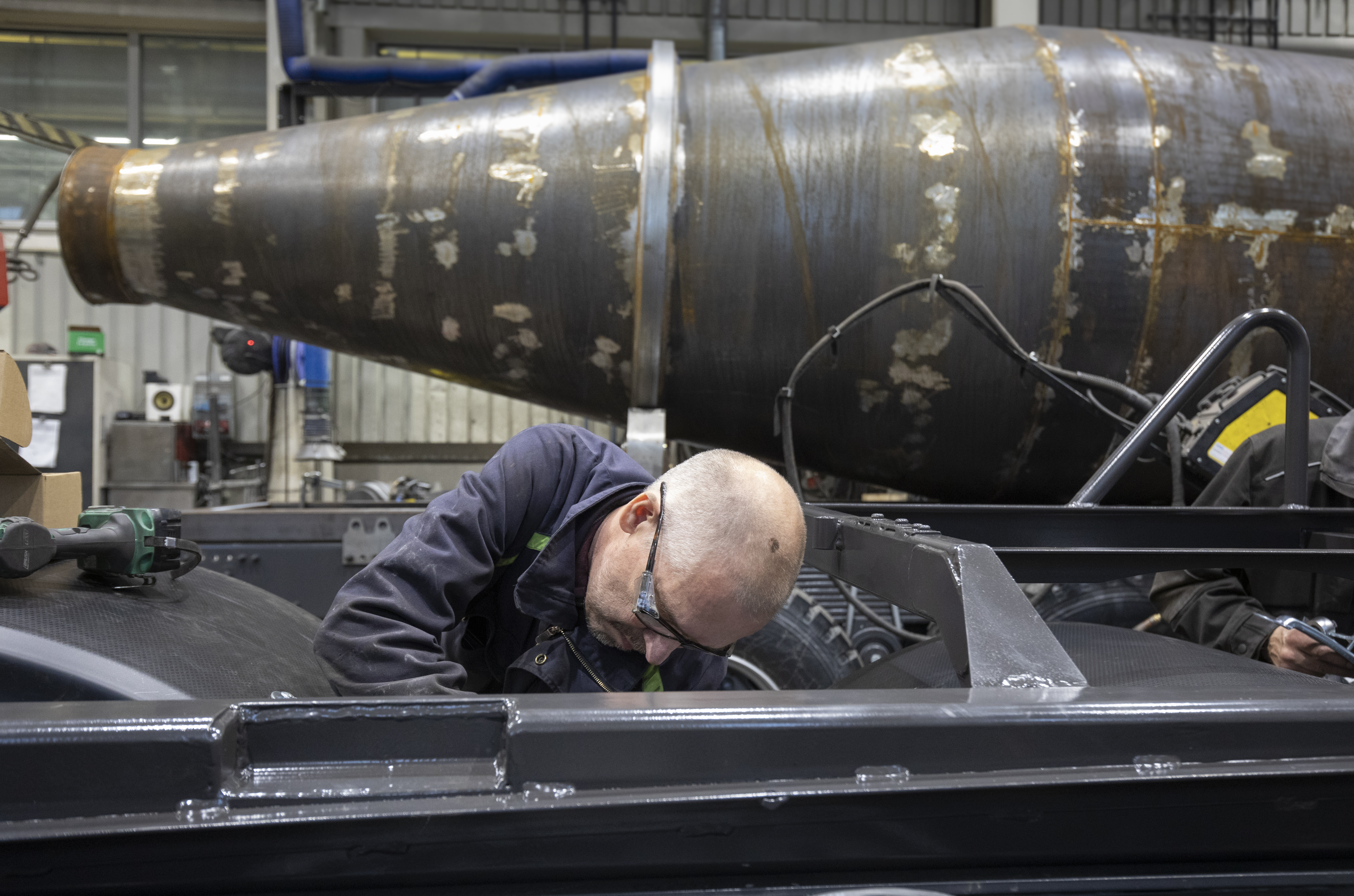 Mekanikern Stefan Kalla från företaget Rönnqvist och Wettianen monterar delar till tombolapåbyggnaden på ett betongfordon.