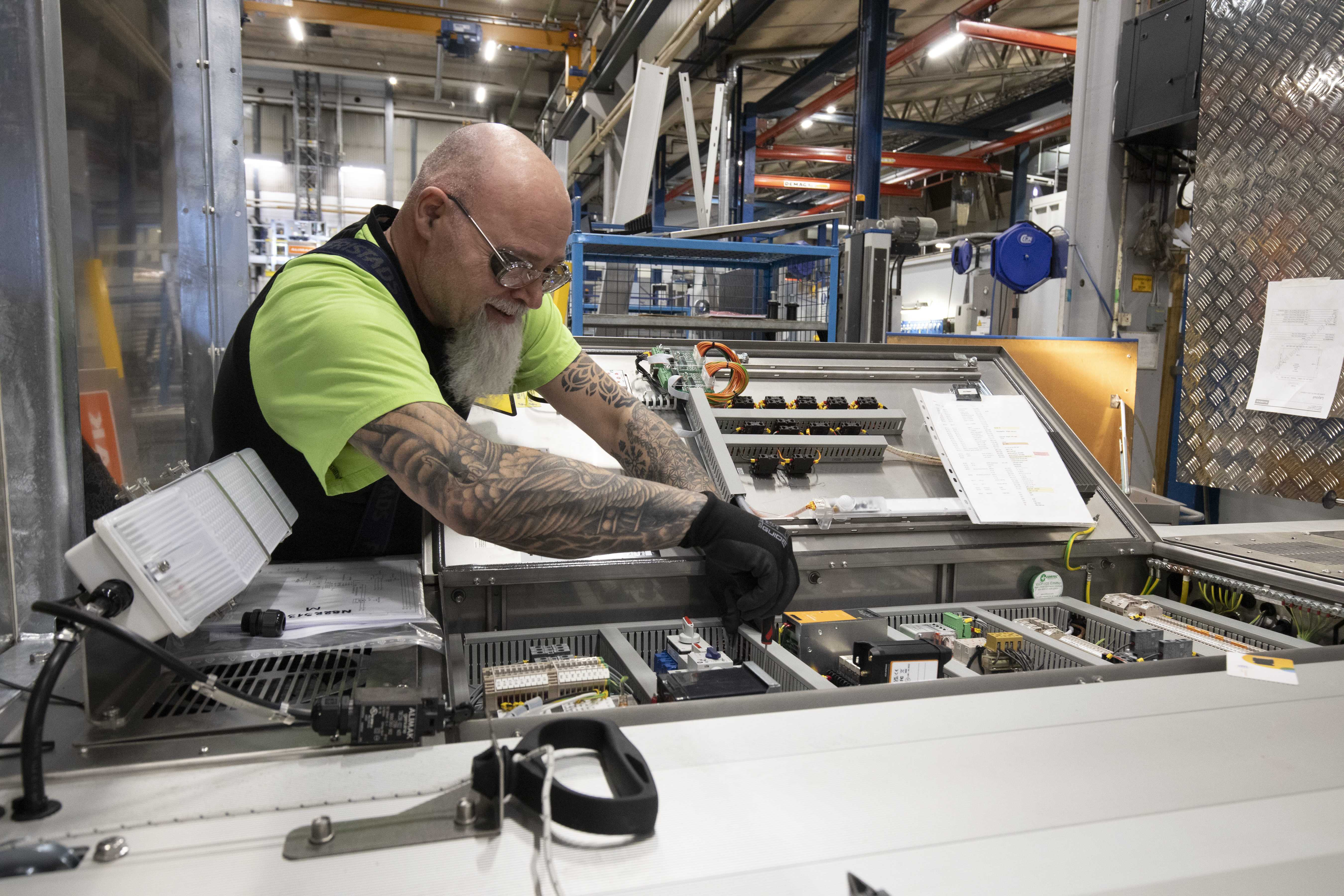 Industrihissarna som ska installeras permanent tillverkas mer manuellt pga. mer precisa kundanpassningar i mer varierande miljöer. Erik Wakker kopplar ihop elen till manöverpanelen.