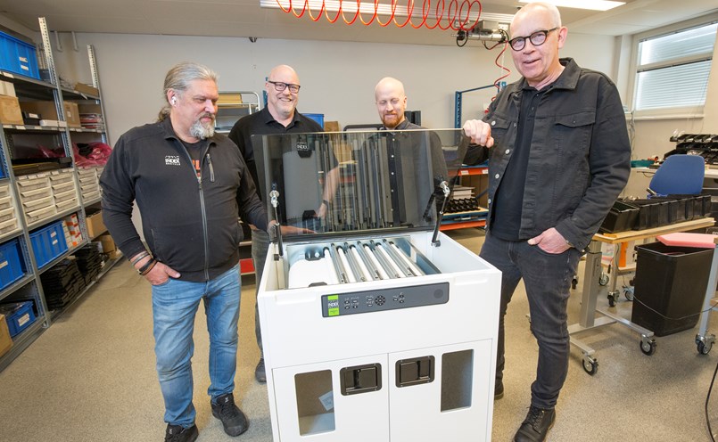De fyra delägarna visar upp den senaste skapelsen som är den snabbaste skrivaren som skriver ut knappt 1200 sidor i timmen. Jan Palovaara, inköpschef, Nils Huhta, utvecklingschef, Peter Hallman, export och marknad samt Mikael Vikman Sunna, vd och export.